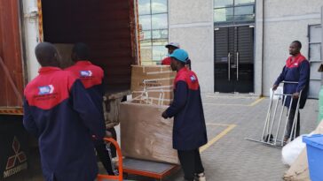 Nairobi Movers team in uniform loading household items and boxes into a large moving truck.